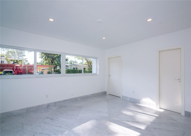 empty room with recessed lighting and marble finish floor