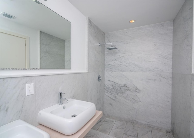 bathroom featuring marble finish floor, visible vents, a shower, and a sink