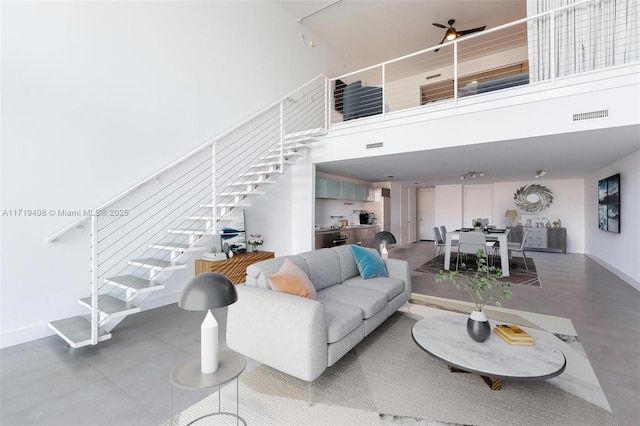 living room with ceiling fan and a high ceiling