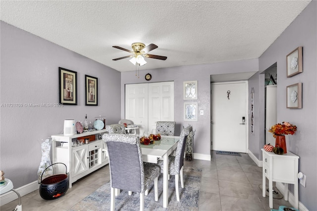 dining area with ceiling fan, light tile patterned floors, and a textured ceiling