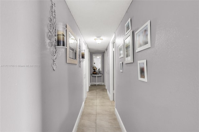 corridor featuring light tile patterned floors and a textured ceiling