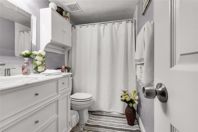 bathroom featuring vanity, curtained shower, and toilet