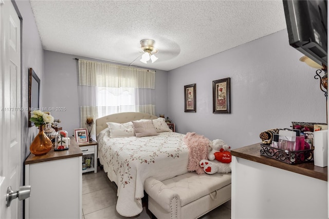 tiled bedroom featuring a textured ceiling and ceiling fan