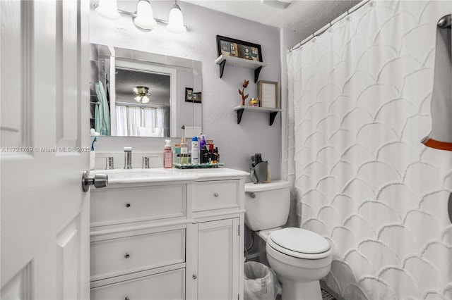 bathroom featuring vanity, a textured ceiling, toilet, and walk in shower