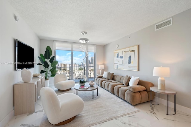 living room featuring a textured ceiling, marble finish floor, visible vents, and baseboards