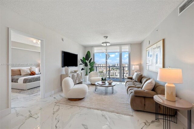 living room featuring a chandelier and a textured ceiling