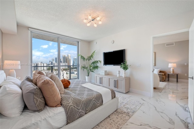 bedroom with a textured ceiling, marble finish floor, baseboards, and access to exterior