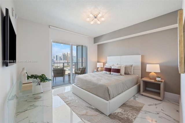 bedroom featuring a textured ceiling, baseboards, marble finish floor, access to outside, and a view of city