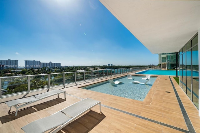 view of pool with a fenced in pool and a city view