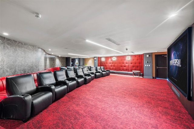 cinema room with wallpapered walls, carpet, visible vents, and baseboards