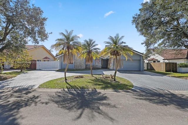 11340 SW 1st St, Coral Springs, FL 33071 - view of front facade featuring fence, decorative driveway, and an attached garage