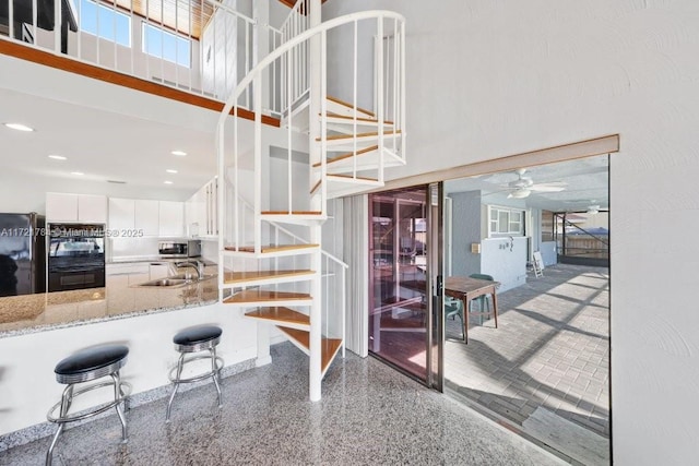 11340 SW 1st St, Coral Springs, FL 33071 - stairway with a high ceiling, ceiling fan, and speckled floor