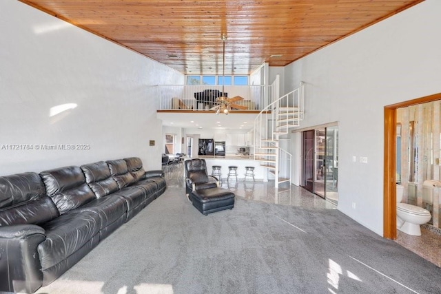 living room featuring a towering ceiling and wooden ceiling