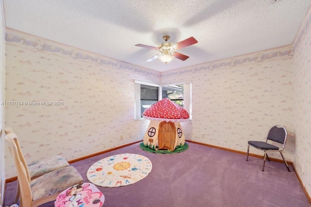 playroom with ceiling fan, carpet, and a textured ceiling