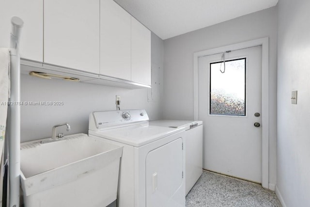 clothes washing area with sink, cabinets, and washing machine and clothes dryer