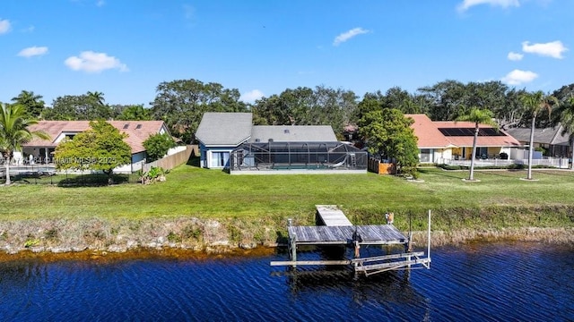 dock area featuring a water view, a yard, and glass enclosure