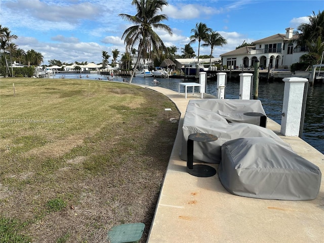 view of dock featuring a water view and a yard