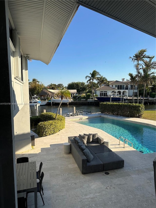 view of swimming pool featuring a water view and a patio