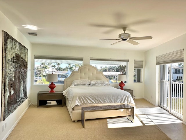 carpeted bedroom with ceiling fan and multiple windows