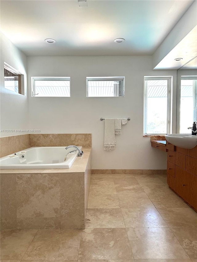 bathroom featuring vanity and a relaxing tiled tub