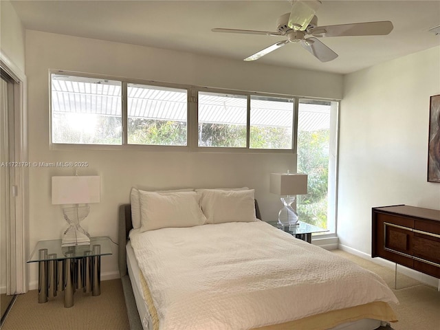 carpeted bedroom with ceiling fan and multiple windows