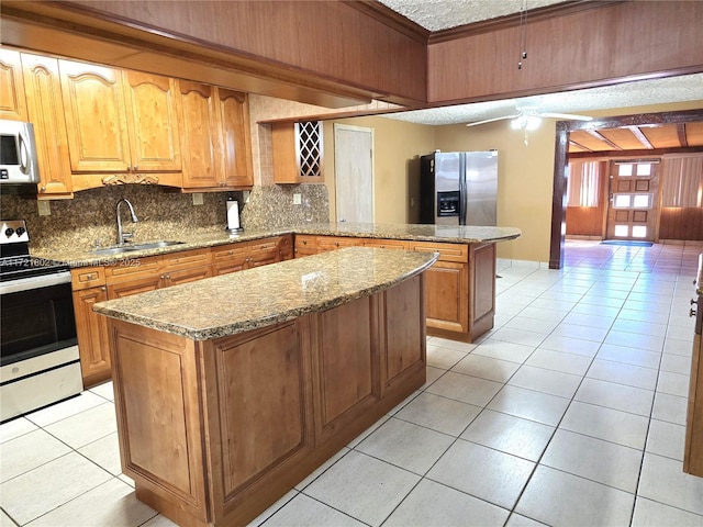 kitchen featuring sink, a center island, stainless steel appliances, decorative backsplash, and light tile patterned flooring