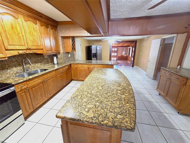 kitchen featuring stainless steel fridge with ice dispenser, a center island, electric range, and sink