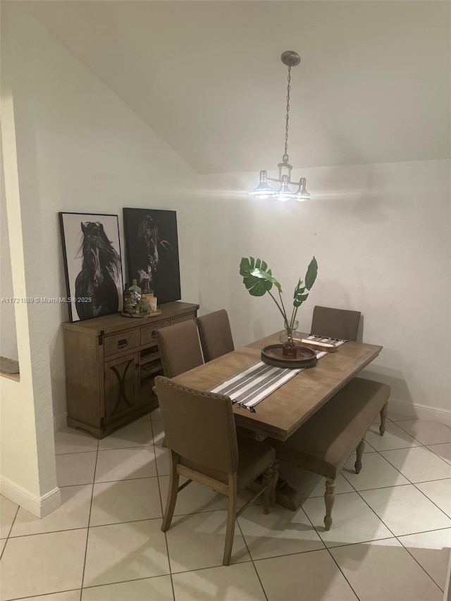 dining room featuring vaulted ceiling and light tile patterned flooring