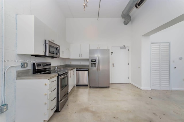 kitchen with white cabinetry, sink, a high ceiling, and appliances with stainless steel finishes