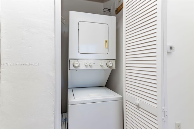 clothes washing area with stacked washer and clothes dryer