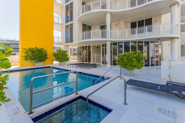 view of swimming pool with a community hot tub and a patio