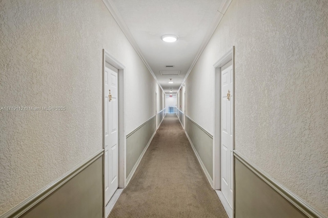 hall with light colored carpet and crown molding