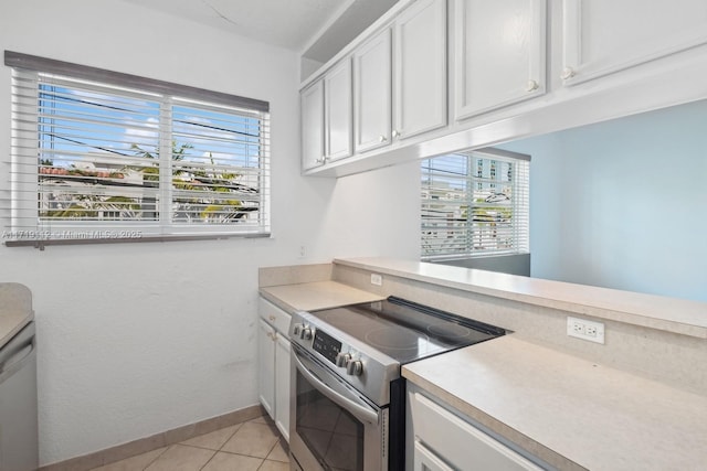 kitchen with white cabinets, high end stainless steel range oven, and light tile patterned flooring