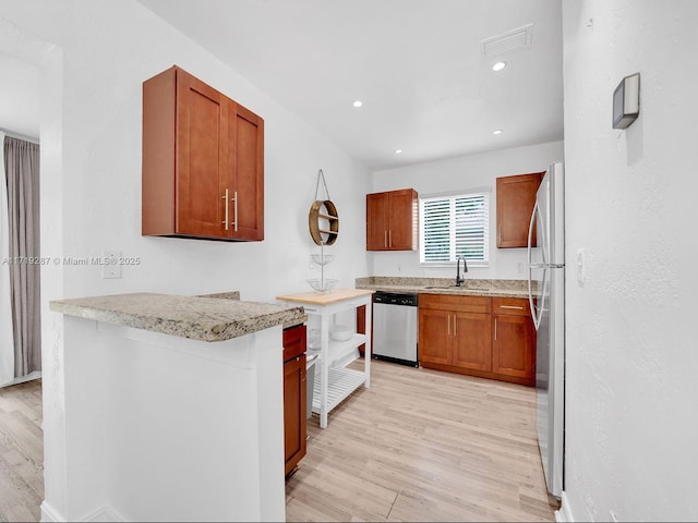 kitchen featuring dishwasher, light wood-type flooring, white fridge, and sink