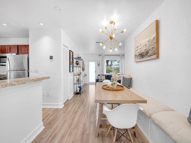 dining room featuring light hardwood / wood-style flooring and an inviting chandelier