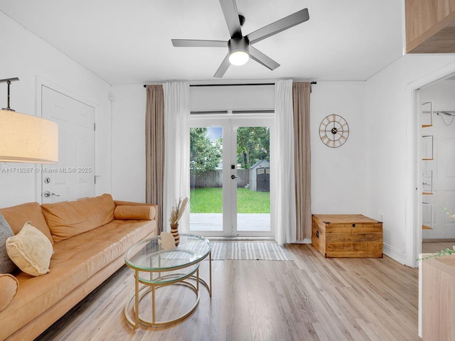 living room featuring ceiling fan, light hardwood / wood-style flooring, and french doors