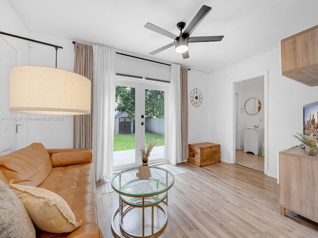 sitting room featuring ceiling fan, light wood-type flooring, and french doors