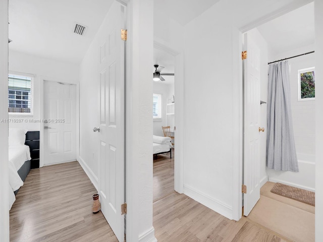 hallway with light hardwood / wood-style floors