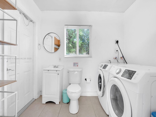 clothes washing area with washer and dryer, light tile patterned floors, and sink