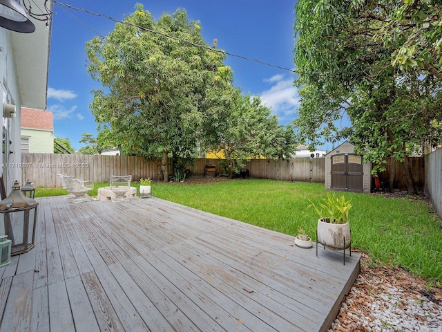 wooden terrace featuring a yard and a shed