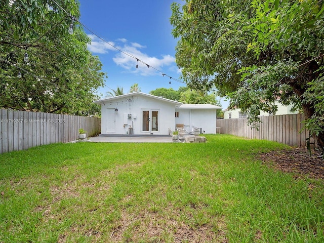 rear view of house with a lawn and a patio area