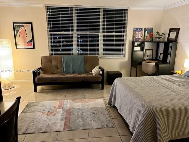 bedroom featuring light tile patterned flooring and crown molding