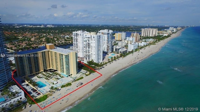 drone / aerial view with a water view, a city view, and a view of the beach