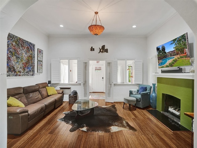 living room with hardwood / wood-style flooring, a wealth of natural light, and ornamental molding