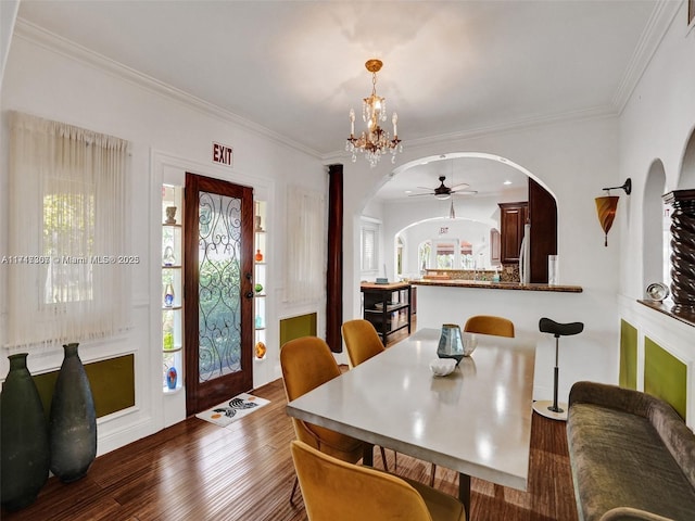 dining area featuring ceiling fan with notable chandelier, dark hardwood / wood-style flooring, and crown molding