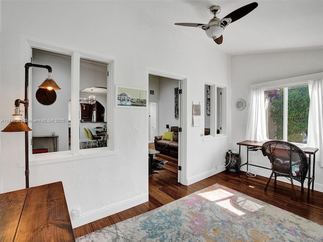 interior space with lofted ceiling, dark wood-type flooring, and ceiling fan with notable chandelier