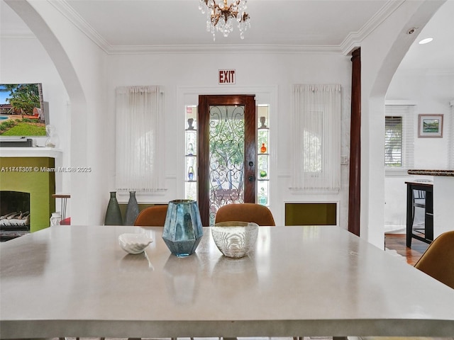 dining space with crown molding, a healthy amount of sunlight, and an inviting chandelier