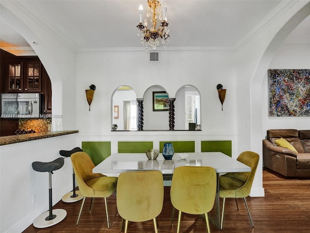 dining space featuring a notable chandelier, dark hardwood / wood-style flooring, and ornamental molding