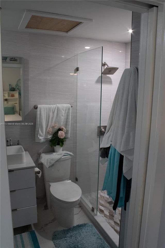 bathroom featuring an enclosed shower, vanity, toilet, and tile walls