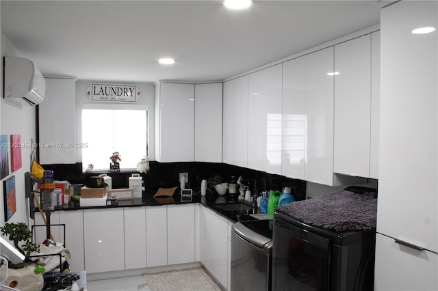 kitchen featuring a wall mounted air conditioner, backsplash, white fridge, washer / dryer, and white cabinets